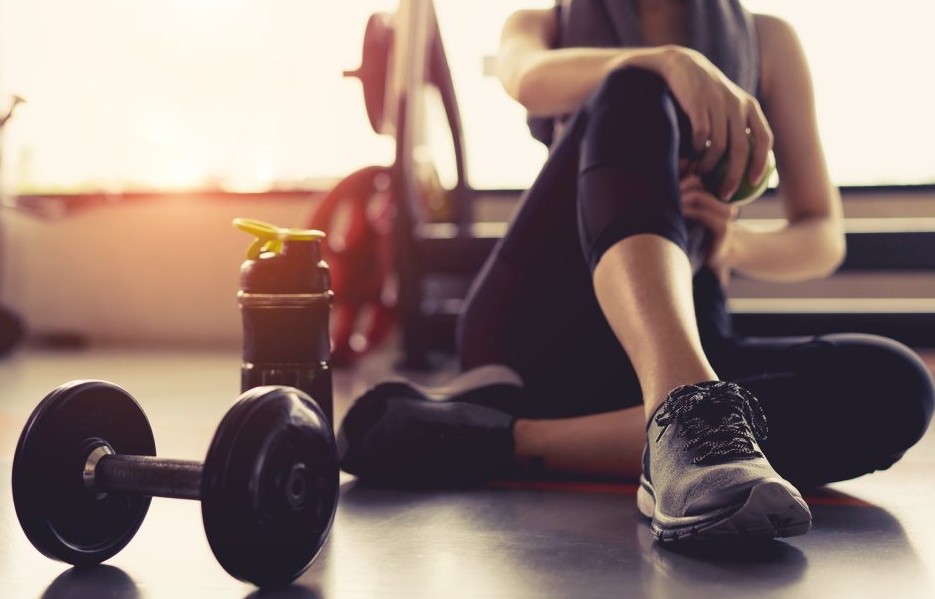 Uomo e donna di mezza età che fanno esercizi di forza in palestra moderna